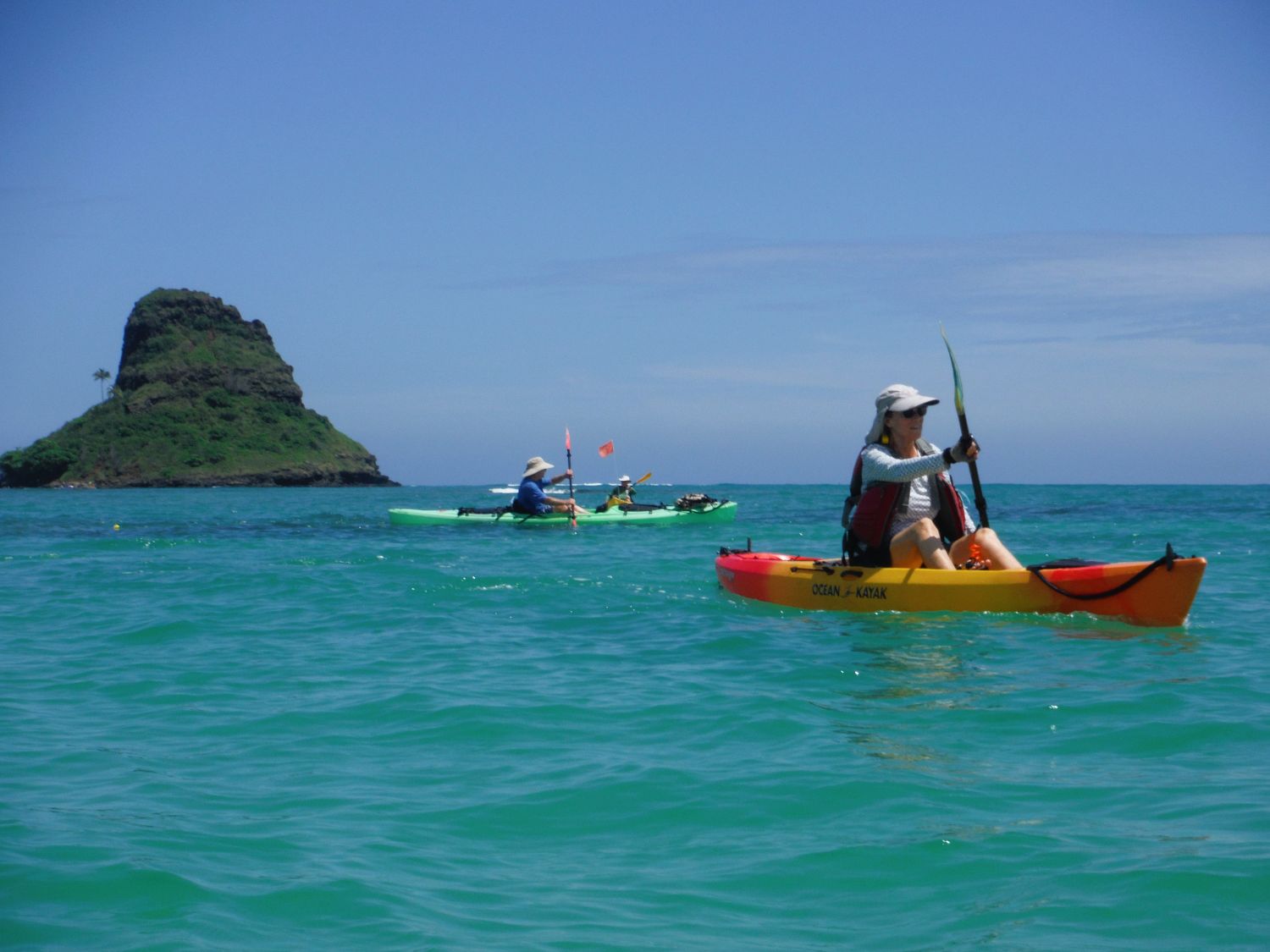 Three kayakers in front of Mokoliʻi
