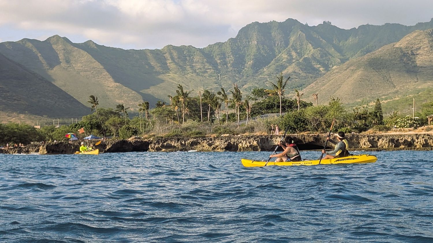 Tandem and single kayak outside of Kalanianaole Beach Park with Waianae mountains in background