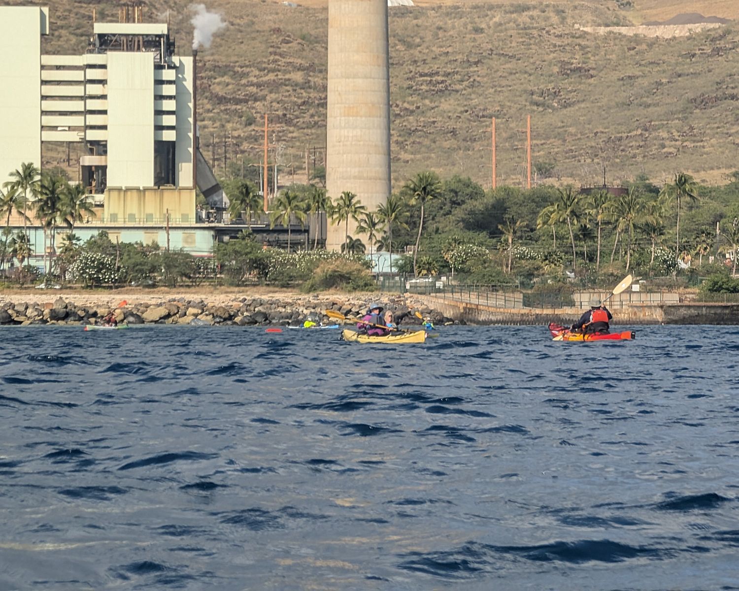 Small group of kayakers on the water outside of the Kahe Power Plant