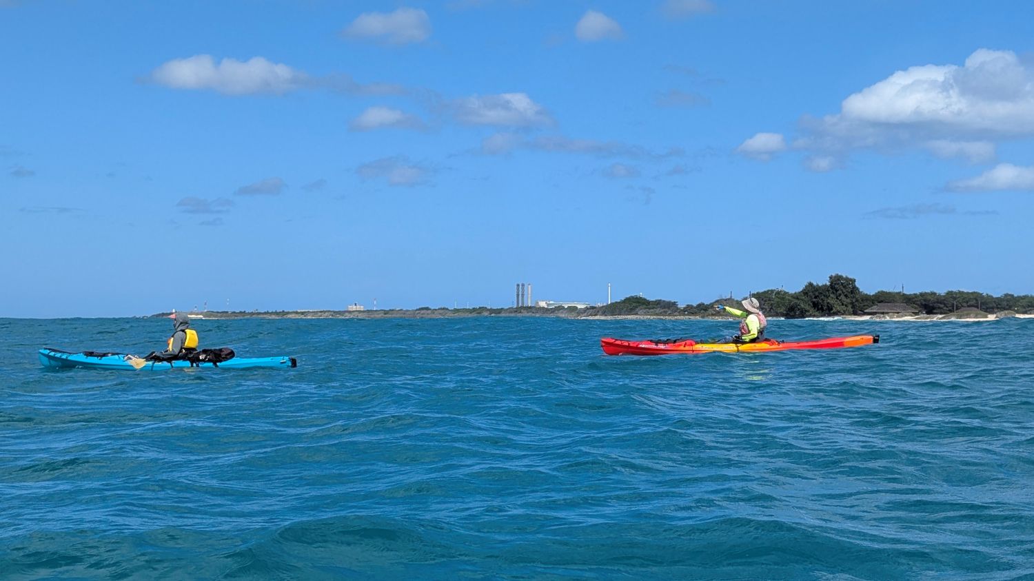 Two kayakers looking at the conditions around Barbers Point