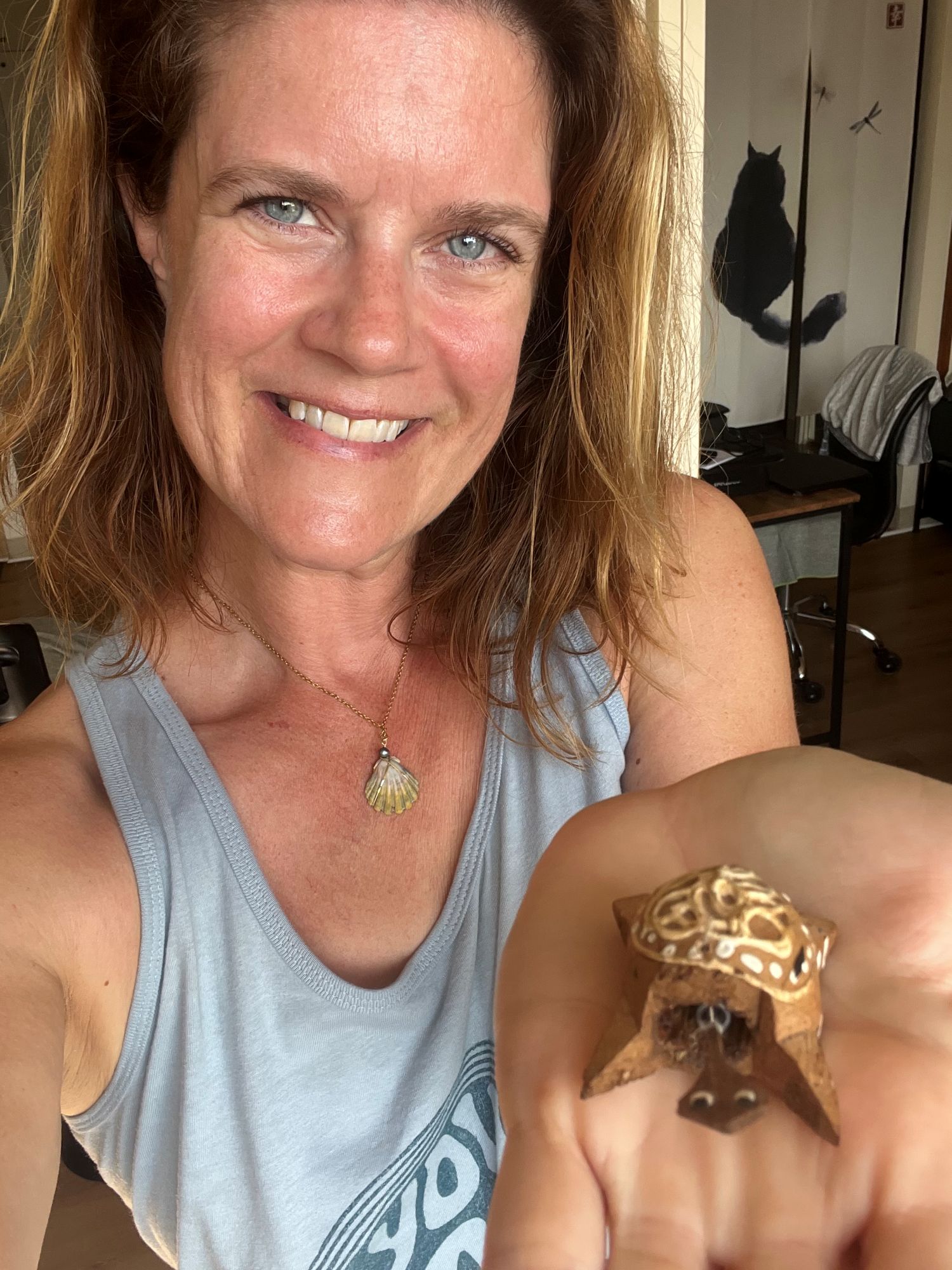 Woman holds a turtle bobblehead carving in her palm