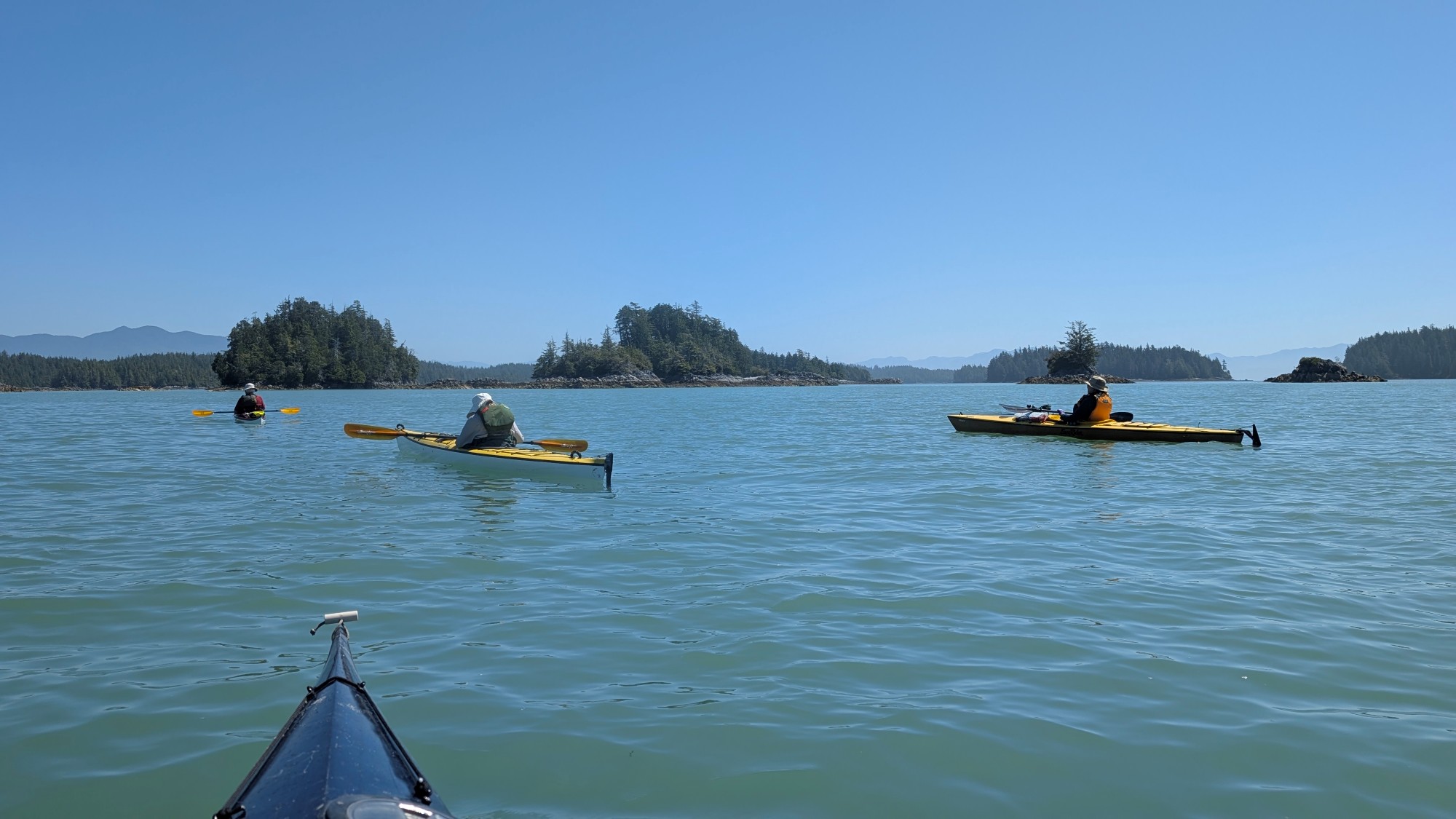 Three kayakers in calm water at the Broken Group Islands