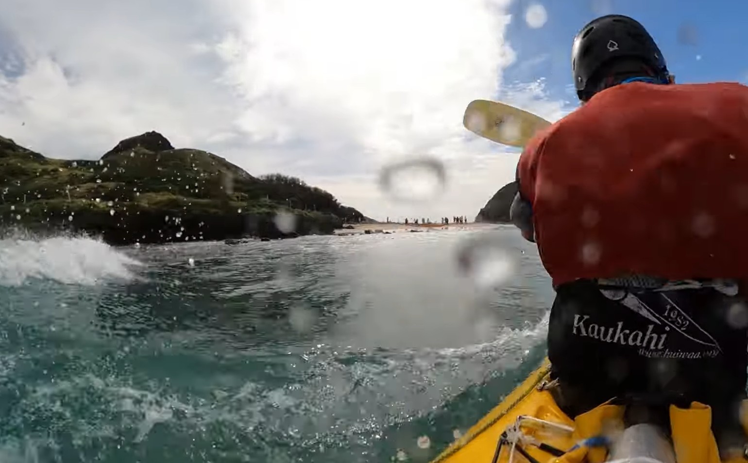 Mokulua Nui to the left of a kakak surfer riding a wave