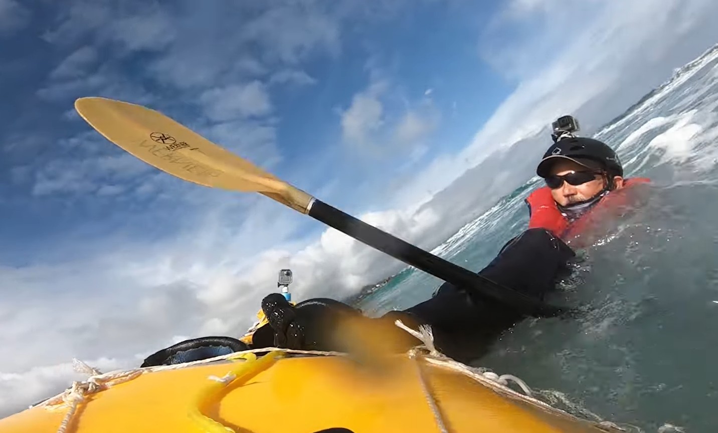 Kayak surfer in the water with his foot caught in the foot strap