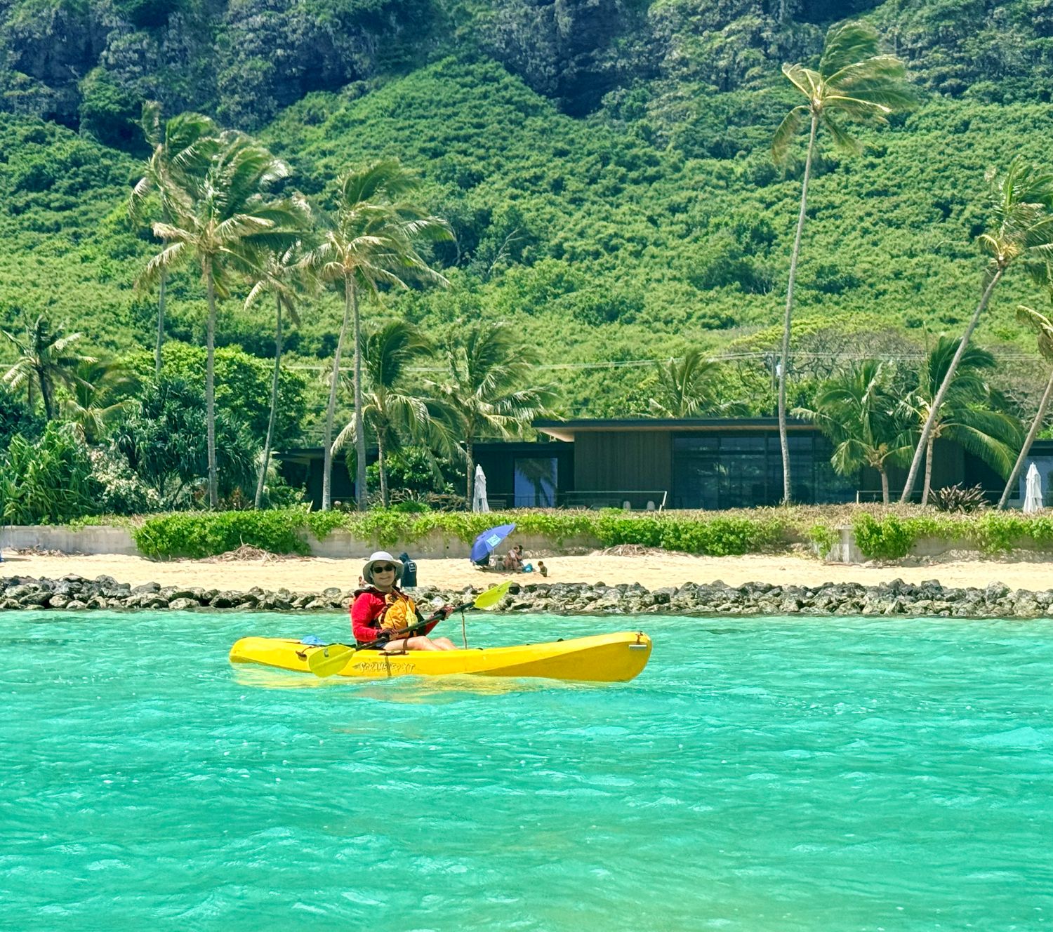 Woman kayaks past the Obama beach house