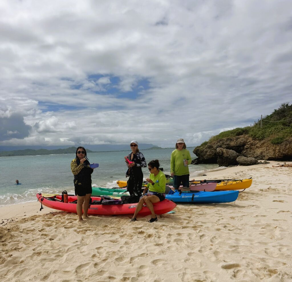 Four kayakers having snacks on Moku Nui