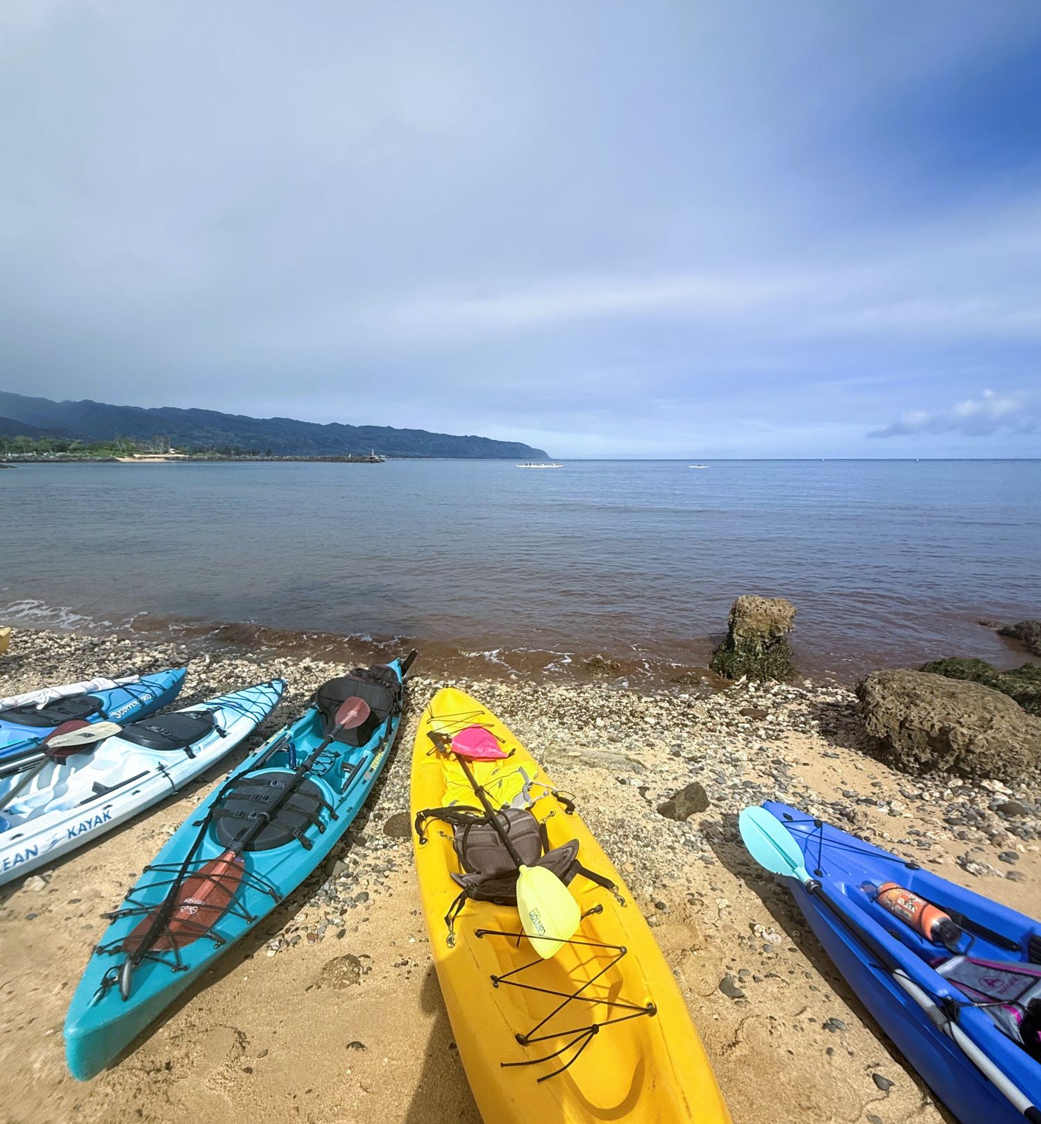 Kayaks on the beach with Mokuleia and Kaena Pt on the horizon