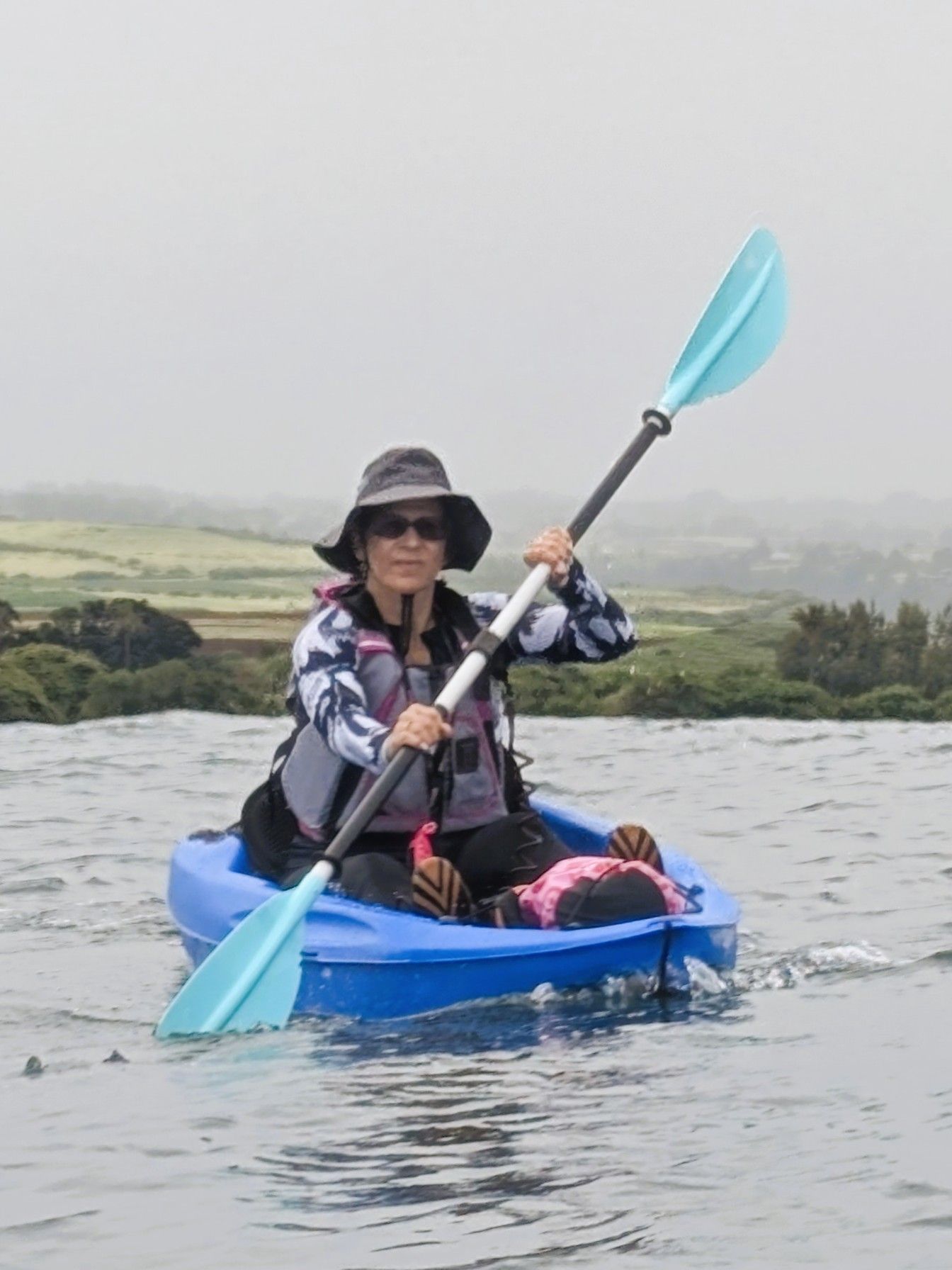 Trina paddling in a little blue kayak